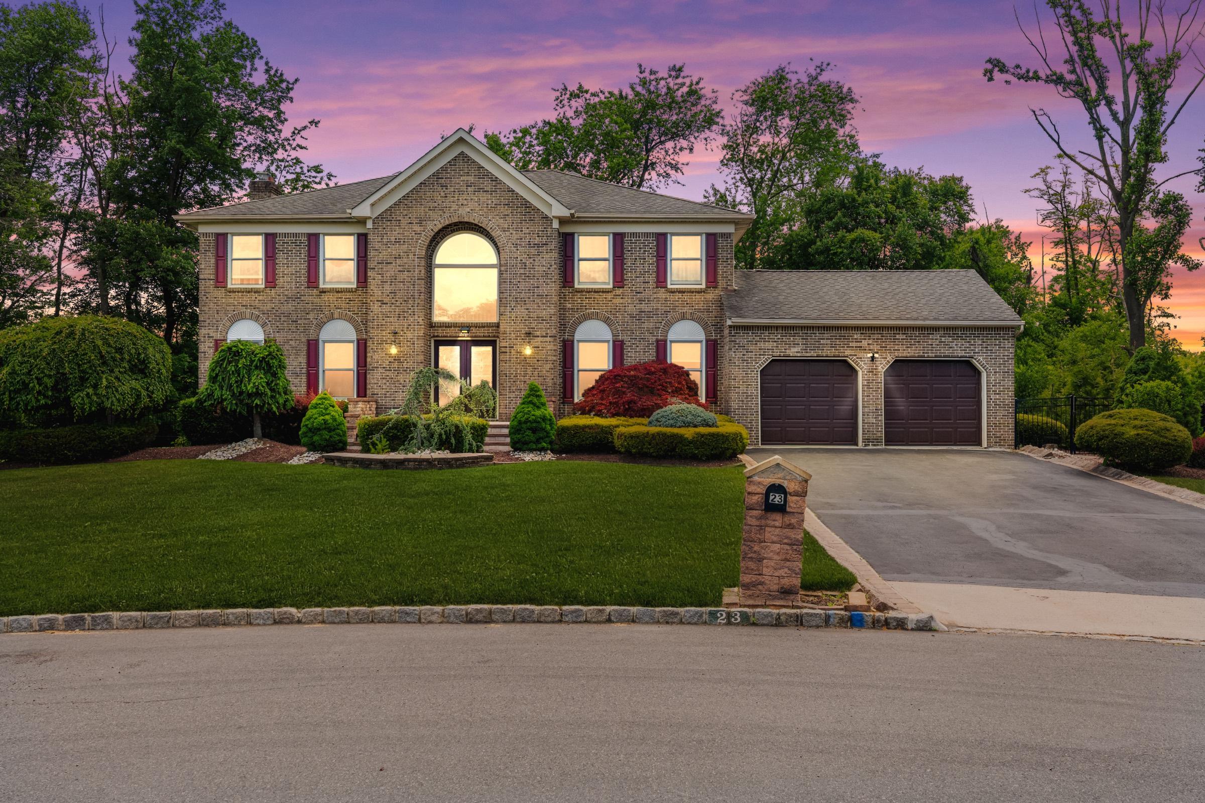 Brick colonial home at twilight with a glowing pink sky, Marlboro NJ